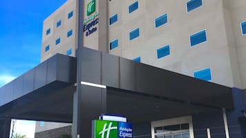 Modern hotel with a grid-patterned facade, featuring a prominent entrance and covered walkway.