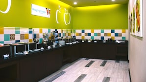 Un área de cocina luminosa con una pared verde, un letrero que dice Desayuno Express y un salpicadero de azulejos.