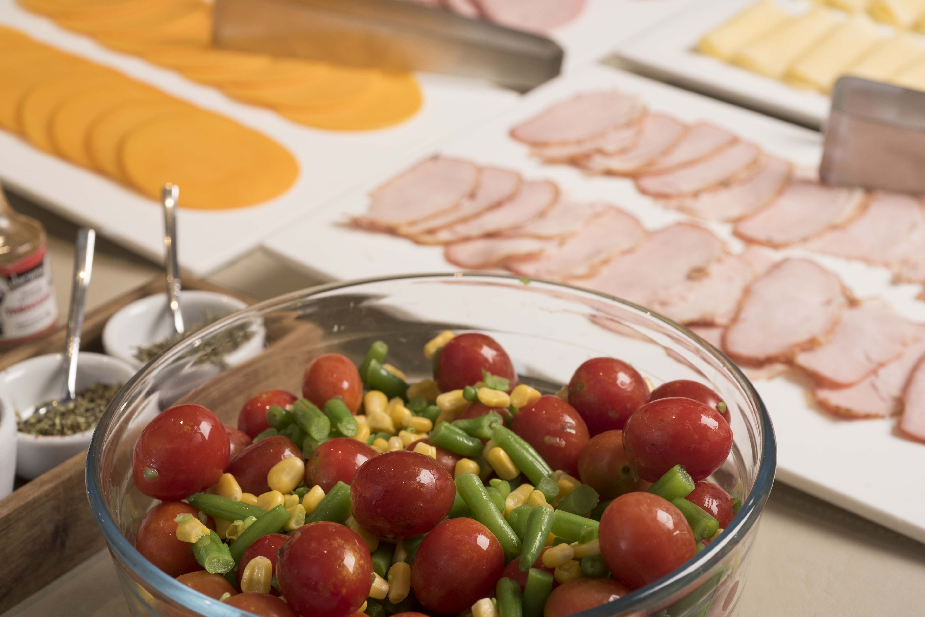 Un buffet proposant une variété de plats, notamment un saladier de légumes variés et des tranches de viande.