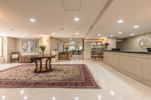 Un'ampia hall con reception, area relax e esposizione di servizi.
