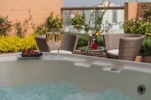 Un bain à remous avec deux coupes de champagne et une assiette de fruits.