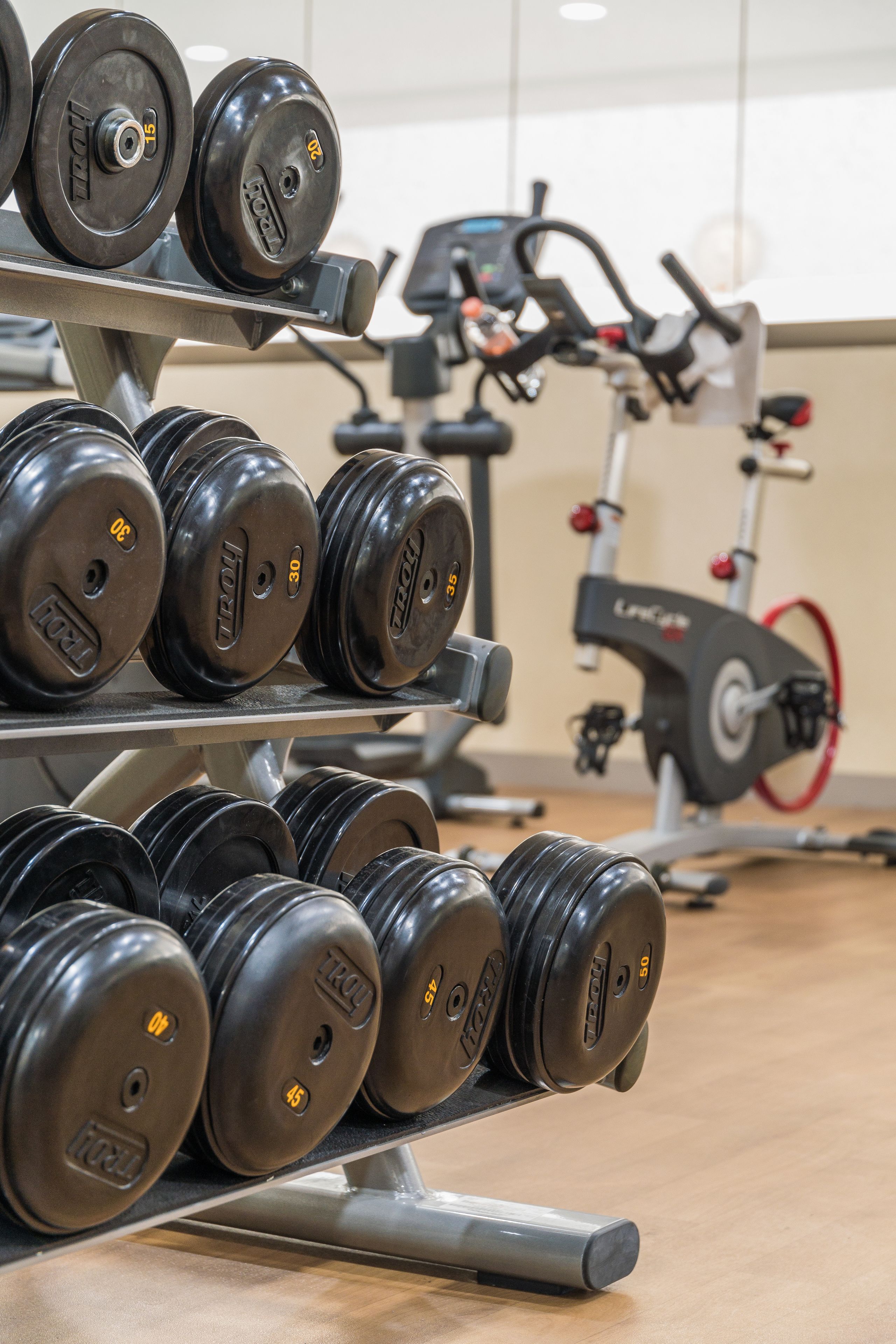 A gym with dumbbells and an exercise bike.