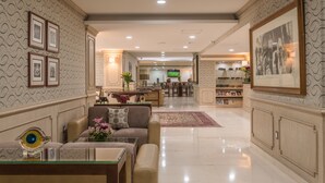 A spacious lobby with a reception desk, seating area, and a television.