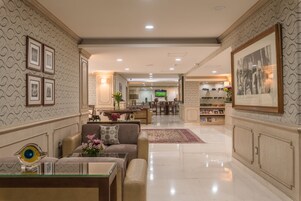 A spacious lobby with a reception desk, seating area, and a television.