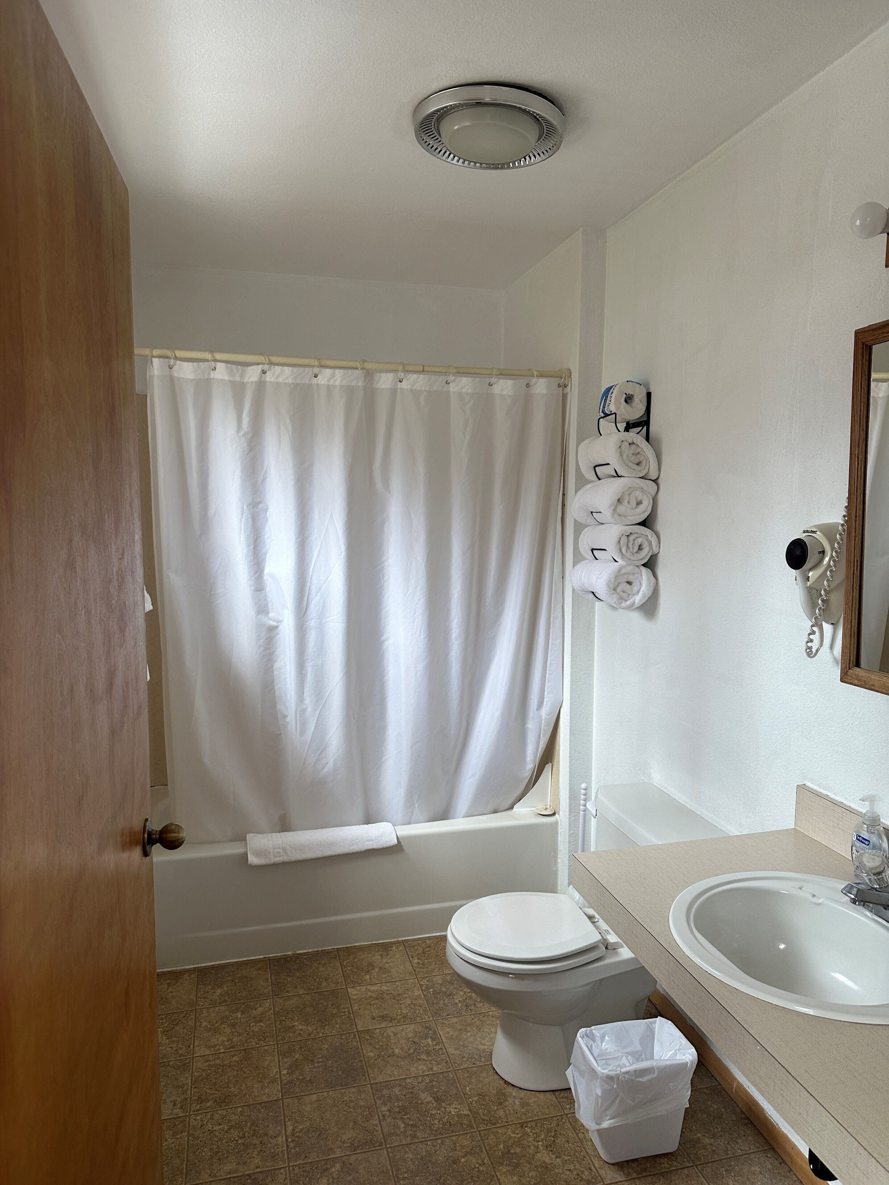 A bathroom with a bathtub, toilet, and sink.