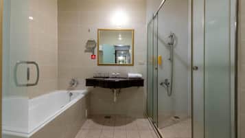 A bathroom with a bathtub, a sink, a mirror, and a shower.
