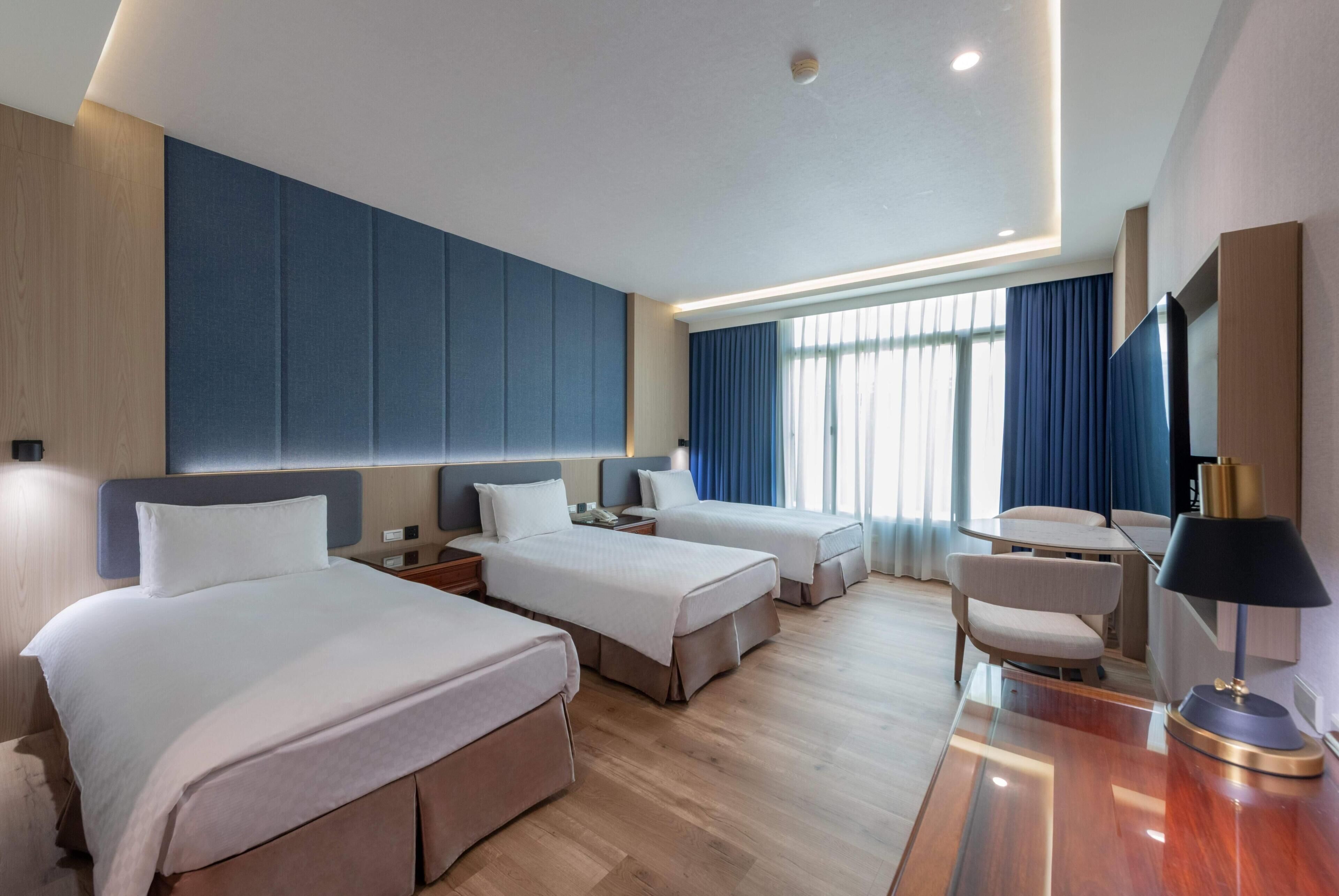 Una habitación de hotel con dos camas, un escritorio y una silla.