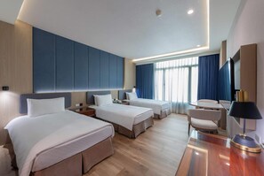 Una habitación de hotel con dos camas, un escritorio y una silla.
