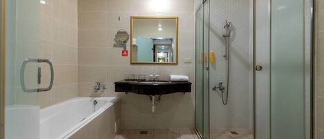 A modern bathroom with a bathtub, sink, and glass-enclosed shower.