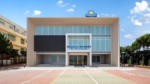 A Days Inn hotel with a modern facade, large windows, and a clear sky. - Days Inn by Wyndham Chiayi (Taibao)