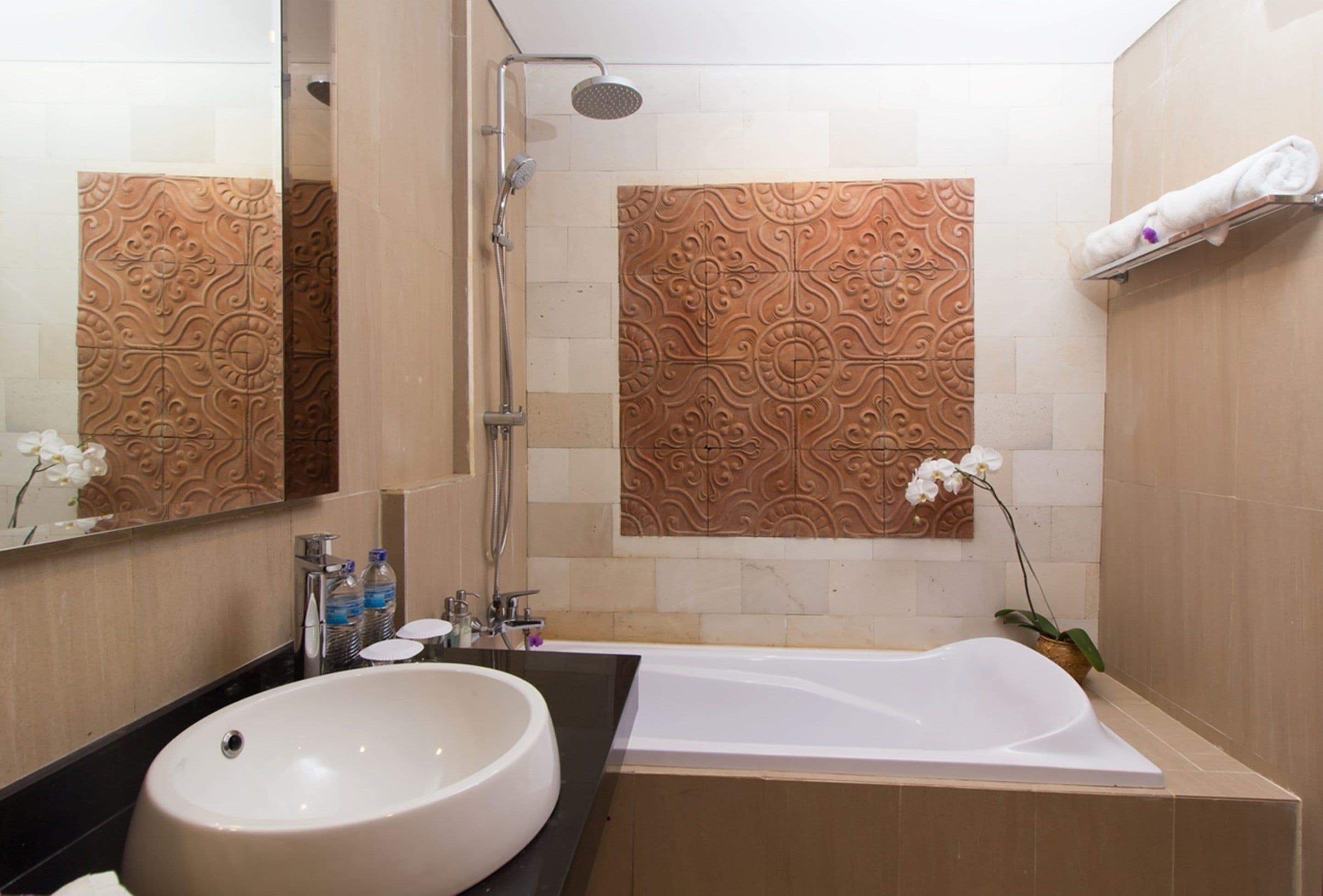 A modern bathroom with a large sink, a bathtub, and a shower.