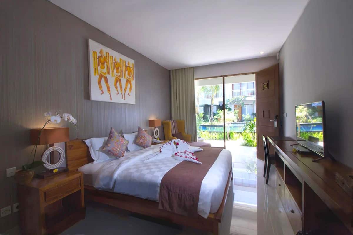 Ein modernes Hotelzimmer mit einem großen Bett, einem Fernseher und Blick ins Freie.
