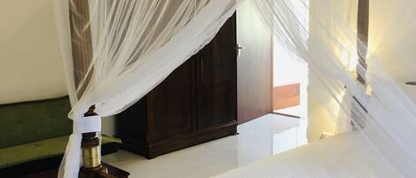 A bed with a wooden frame and a white canopy.