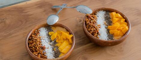 Two bowls of food on a wooden table.