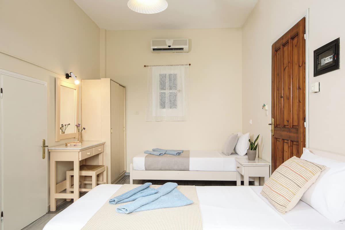 A bedroom with a bed, bedside table, and a wardrobe.