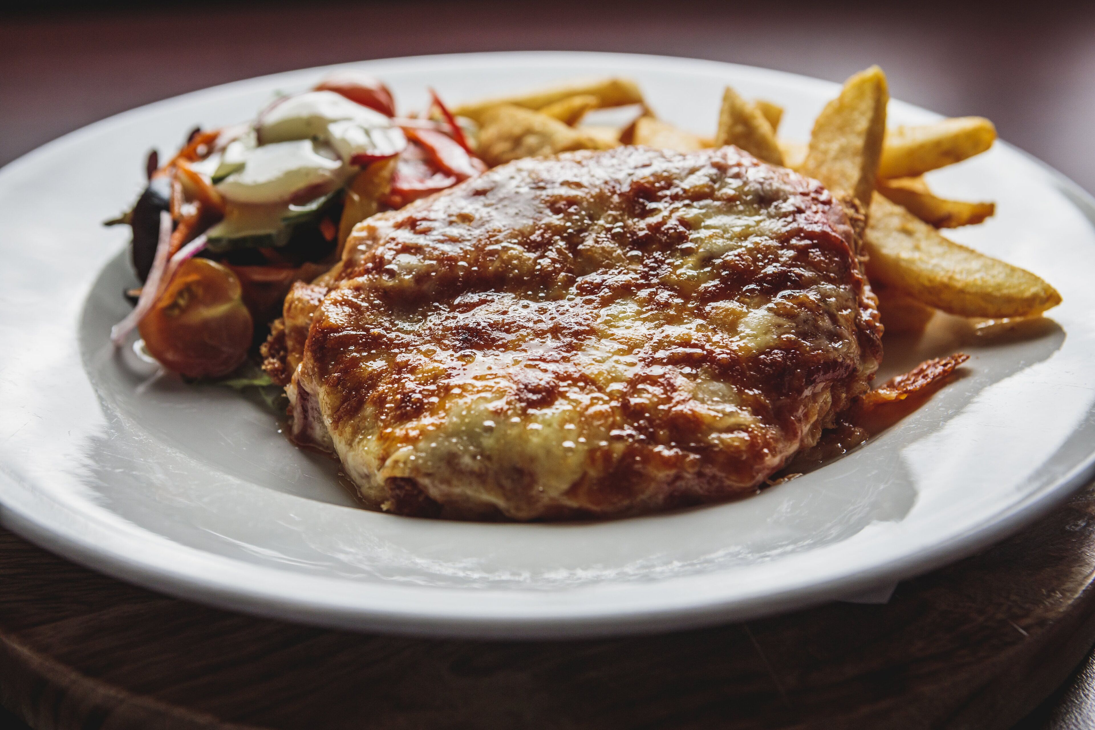 Un plato con una hamburguesa, papas fritas y una ensalada.