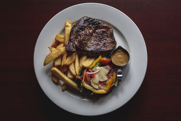 A plate with a steak, fries, and a salad.