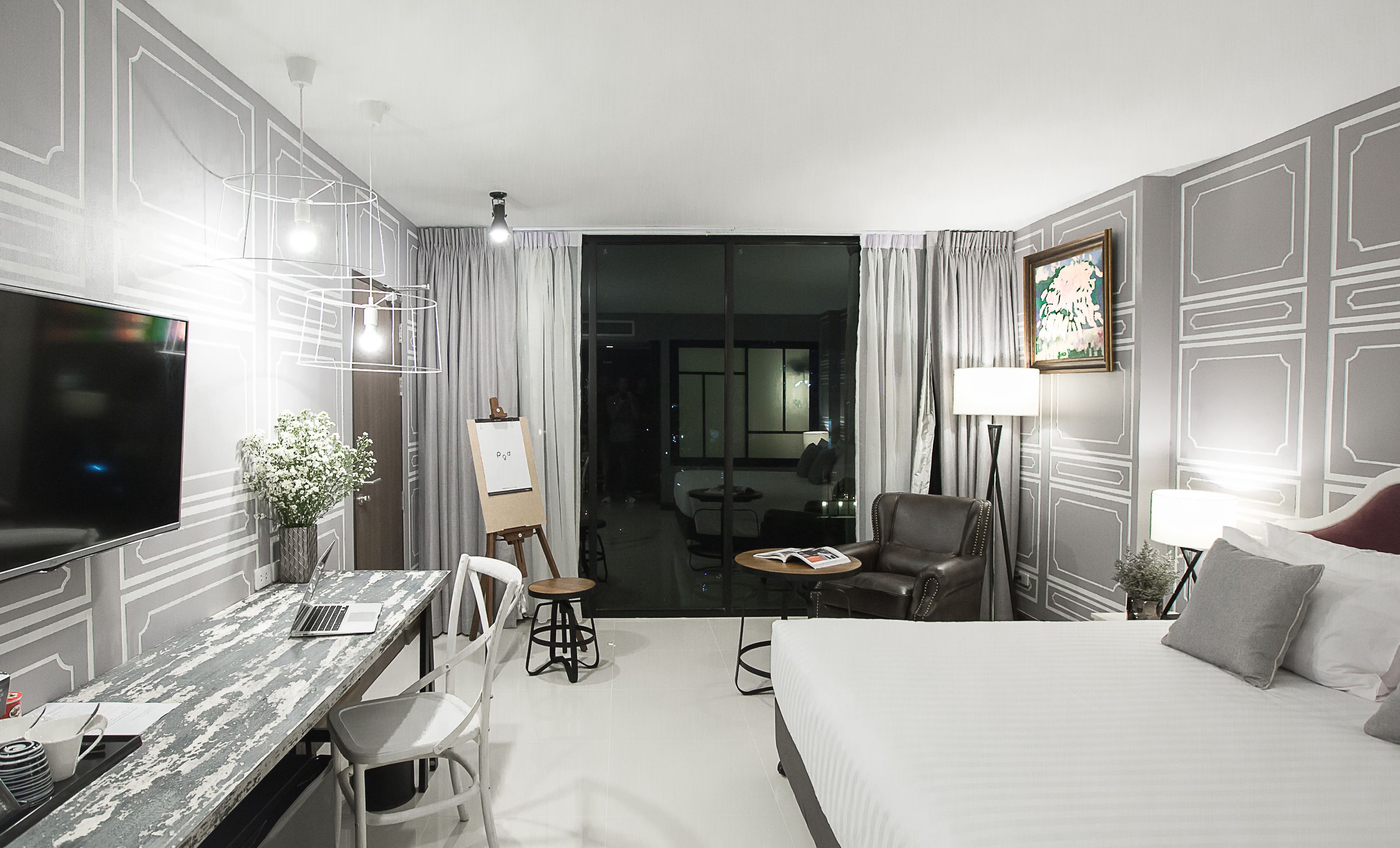 Une chambre d’hôtel équipée d’un lit, d’un bureau, d’une chaise, d’une télévision et offrant une vue sur la salle à manger.