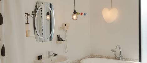 A modern bathroom with a freestanding bathtub, a vanity with a mirror, and a shower area.