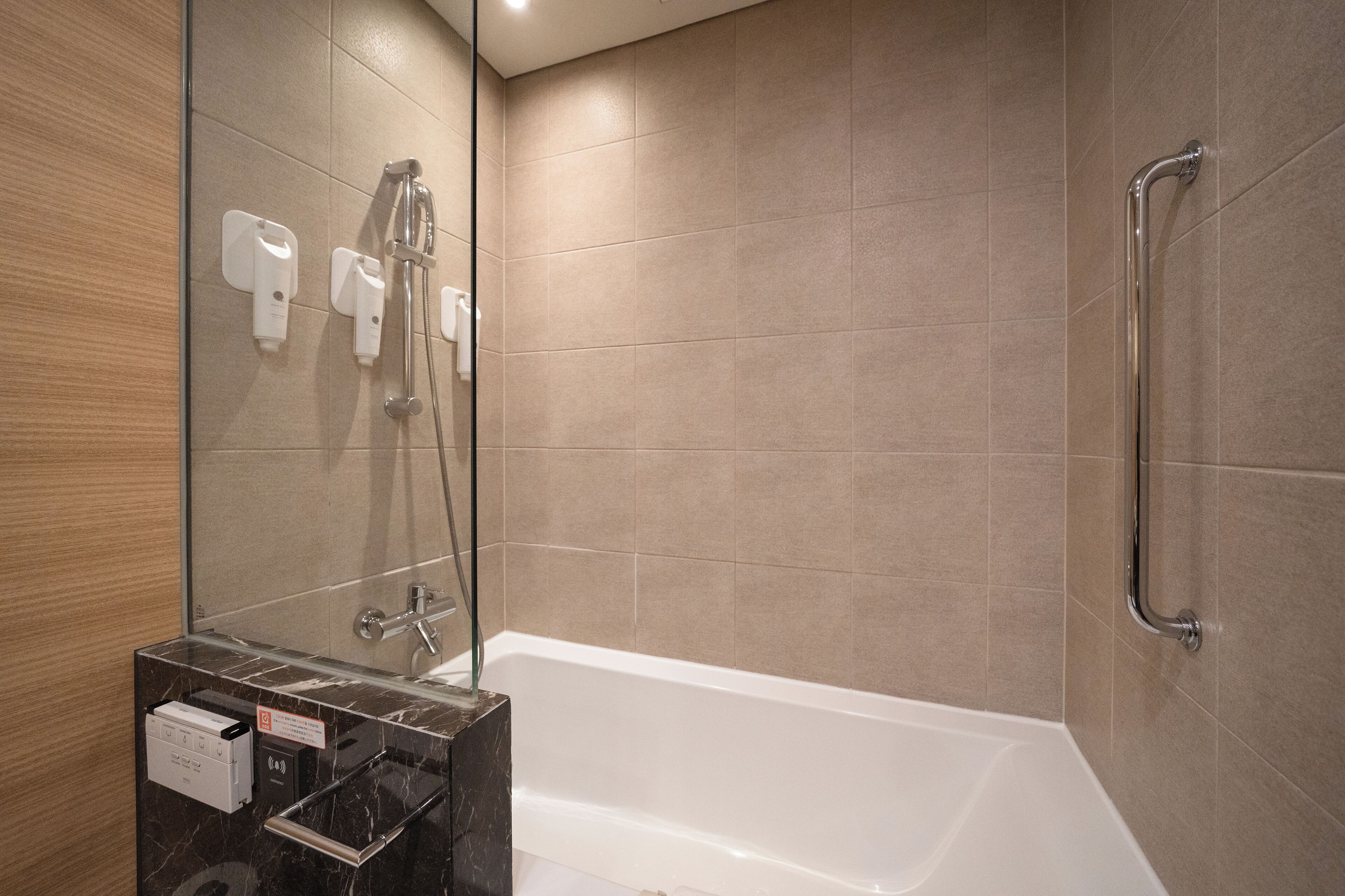 A modern bathroom with a bathtub, a glass-enclosed shower area, and a vanity with a mirror.