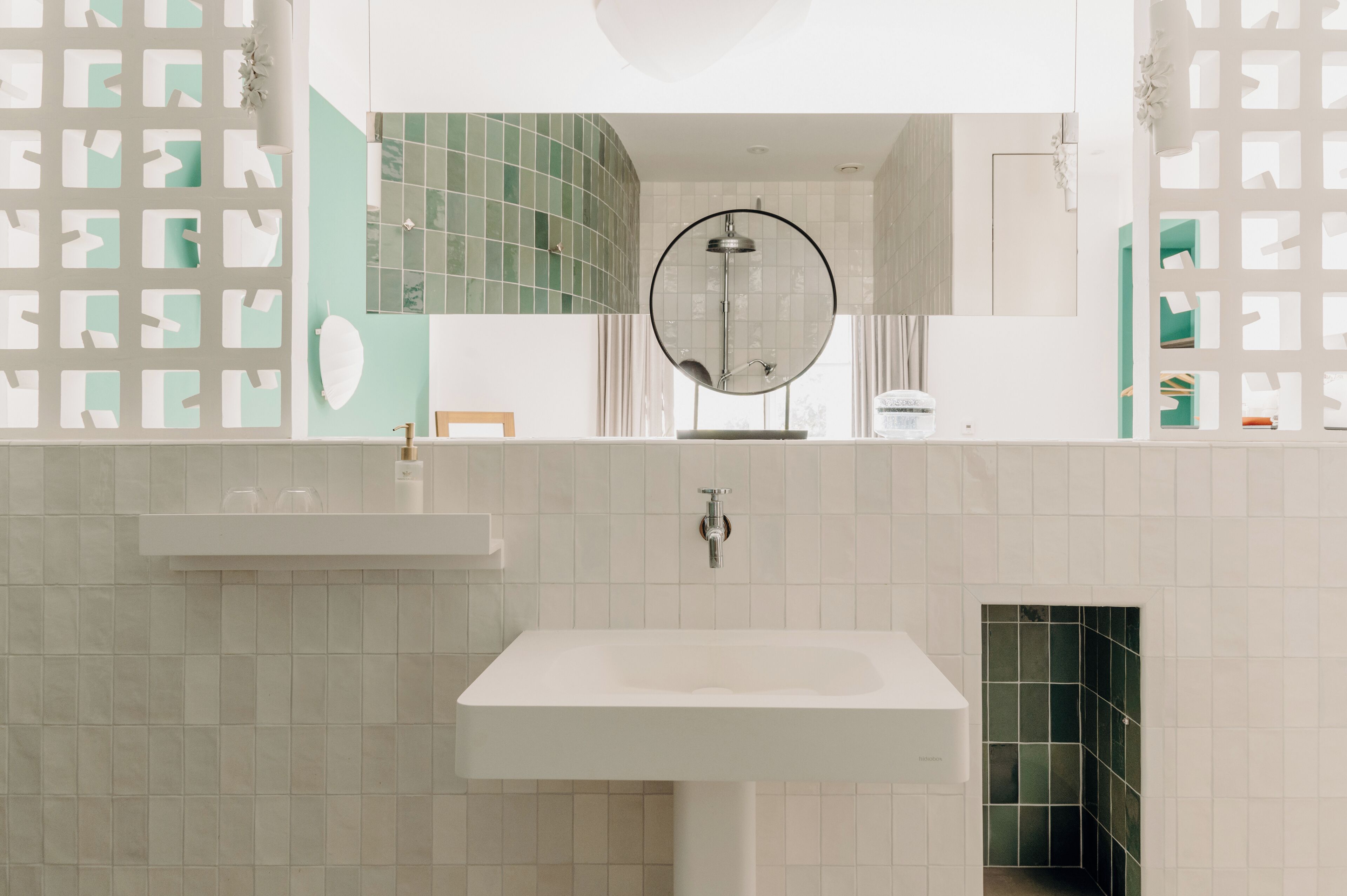 A bathroom with a white sink, a mirror, and a shower.