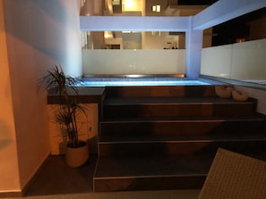 Una piscina al aire libre, sombrillas, sillones reclinables de piscina