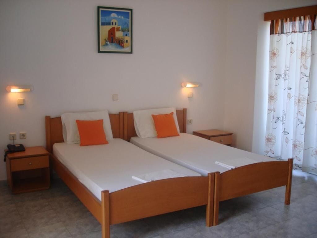 A double bed with a wooden frame, two bedside tables, and a nightstand.