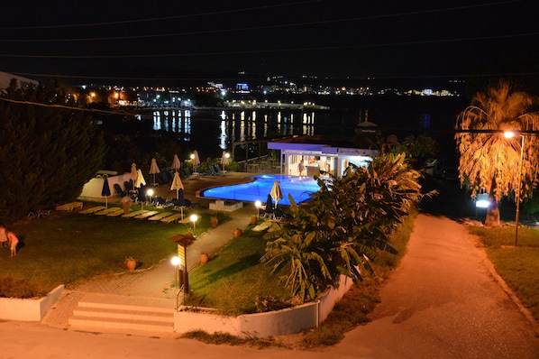 Una piscina al aire libre, sombrillas, sillones reclinables de piscina