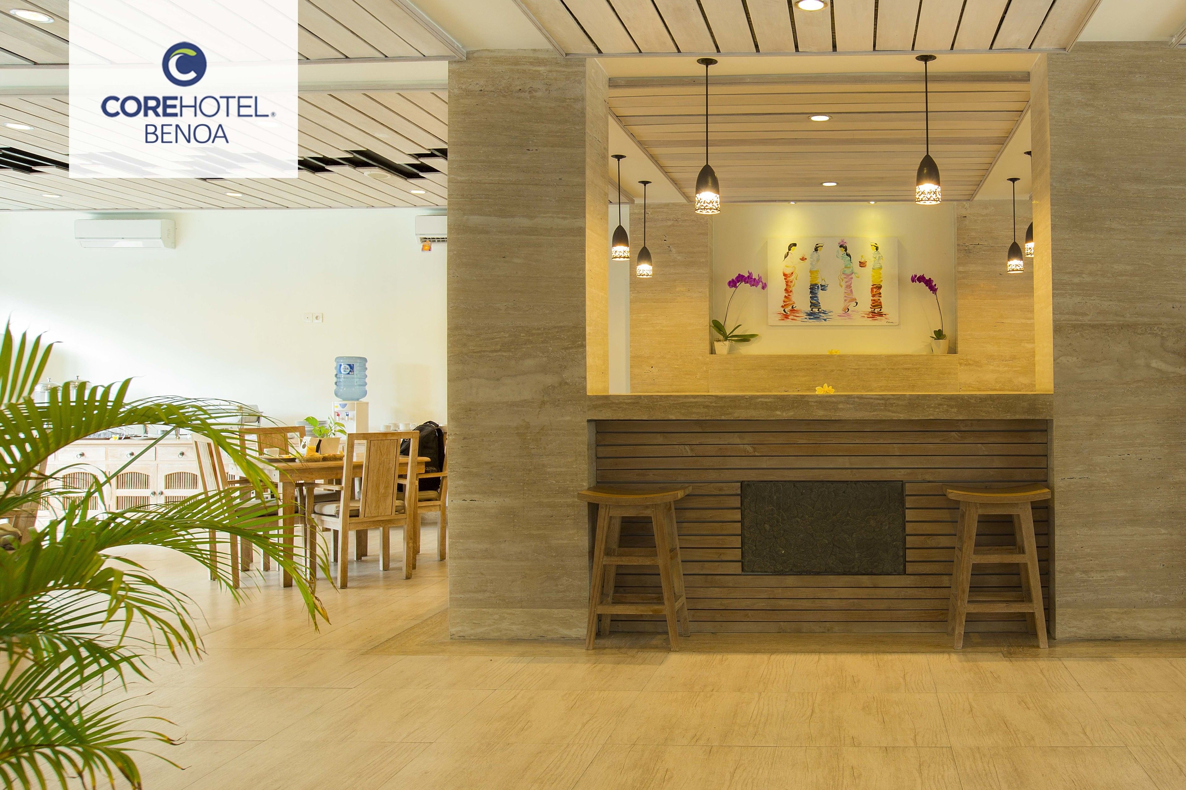 Una zona de recepción con un banco de madera, dispensador de agua y mostrador.
