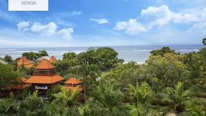 A hotel with traditional architecture, lush greenery, and a view of the ocean. - Core Hotel Benoa (Nusa Dua)