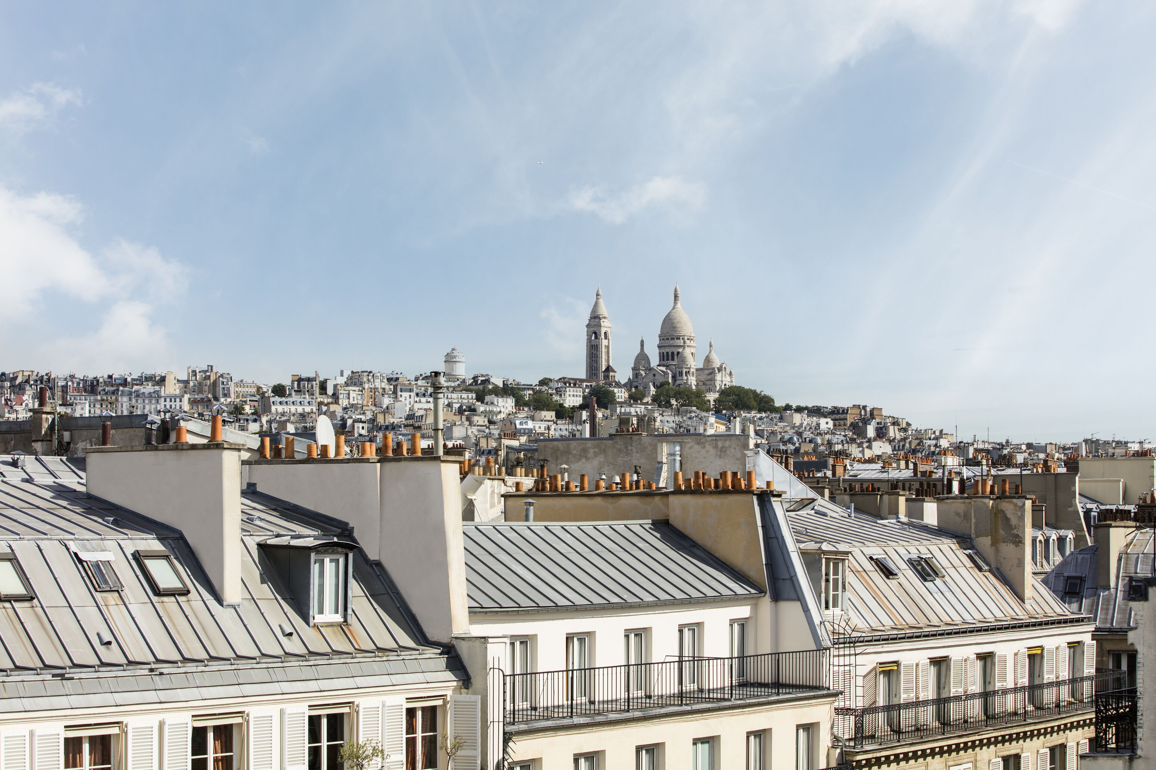 A cityscape with a prominent domed building in the distance, surrounded by densely packed residential buildings.