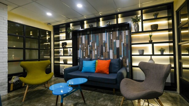 A modern lounge area with a sofa, two armchairs, and a small coffee table. - Value Star Inn (Dagupan)
