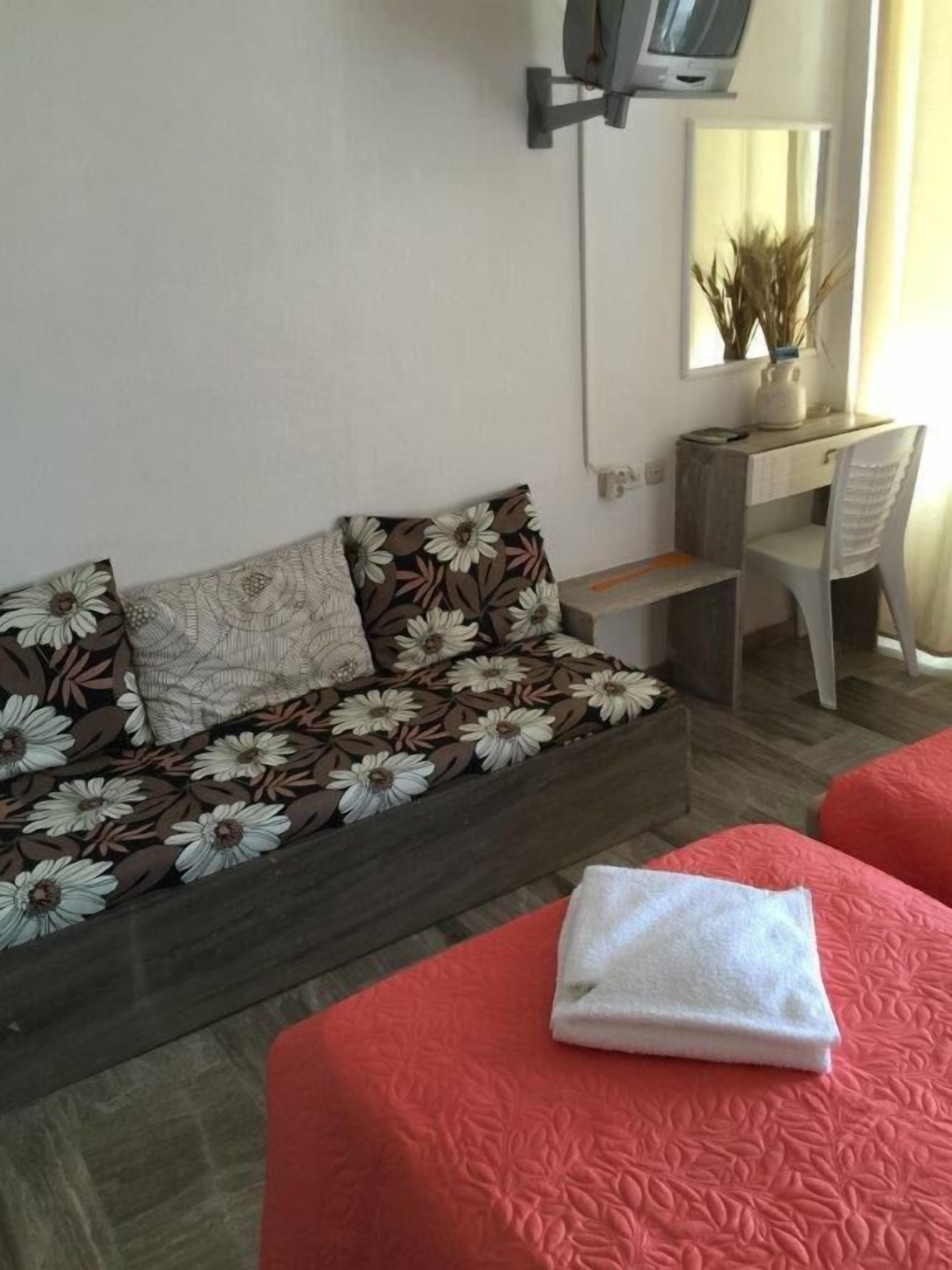 A bedroom with a sofa bed, a desk, and a chair.