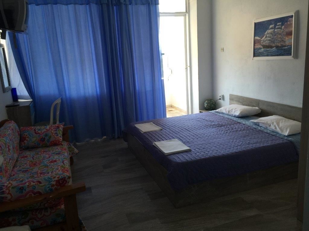 A bedroom with a bed, a chair, and a painting on the wall.