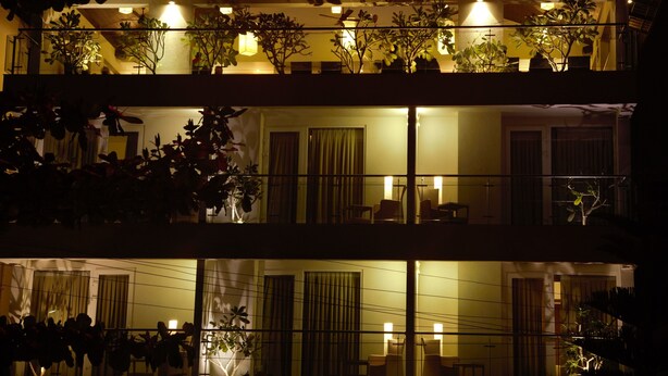 A multi-story hotel with balconies, potted plants, and indoor seating areas. - Temple Tree Hotel (Bengaluru)