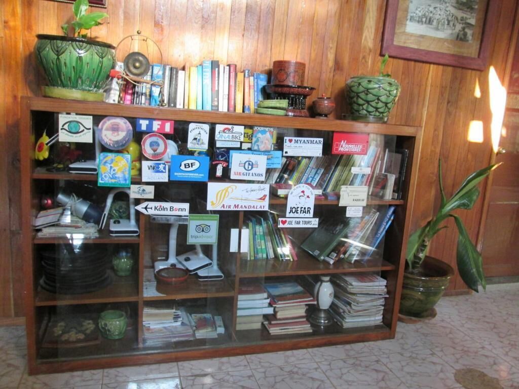 A wooden display case with various travel-related items, including books, postcards, and signs.