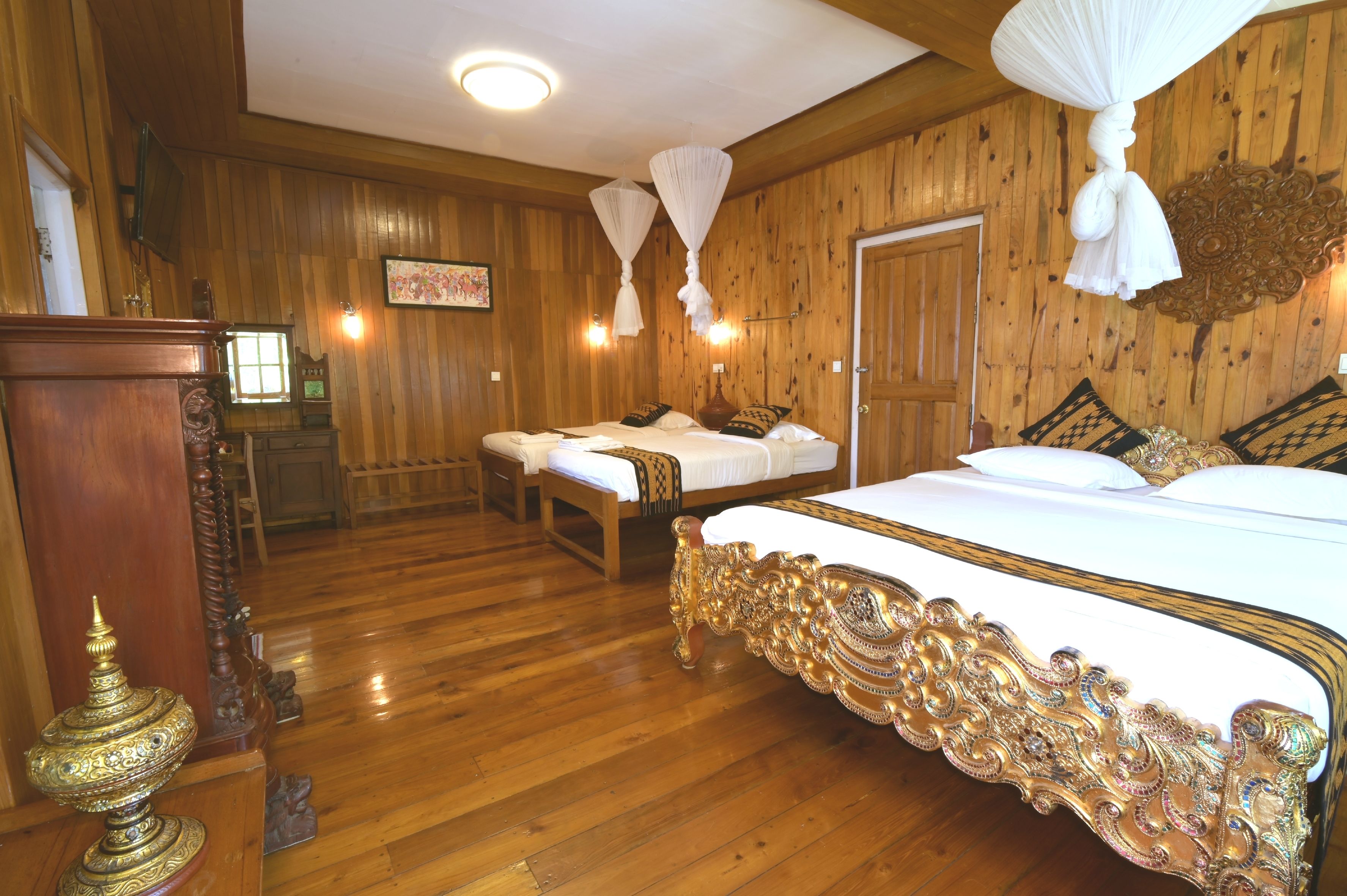 Une chambre dotée d’un grand lit, de deux tables de chevet, d’un plancher en bois et d’un lambris en bois.