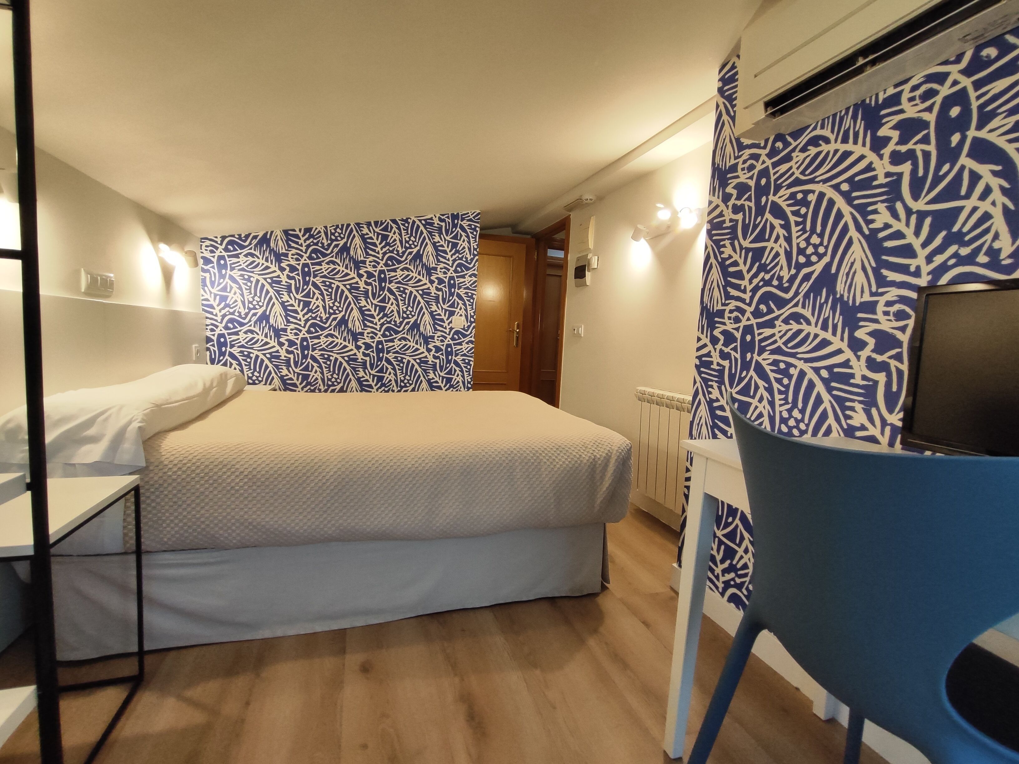 Un dormitorio con una cama, un escritorio y una silla.