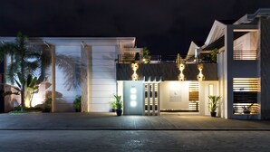 A modern hotel entrance with a number "2537" sign, a "Winds Boutique Hotel" sign, and a well-lit facade with potted plants. - Winds Boutique Hotel (Angeles City)