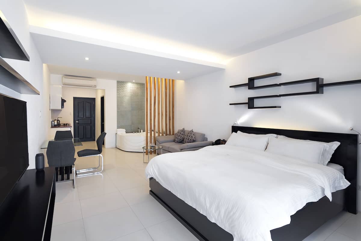 Une chambre moderne avec un grand lit, un bureau et un canapé.