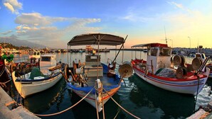 A harbor with several boats docked, a covered area, and a distant mountain. - Hotel Morfeas (Dio-Olympos)