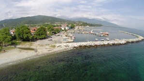 An aerial view of a coastal town with a marina, clear waters, and surrounding hills. - Hotel Morfeas (Dio-Olympos)