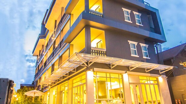 A multi-story hotel with a modern design, featuring balconies and a covered entrance area. - The Battery Park Midtown Boutique (Chiang Mai)