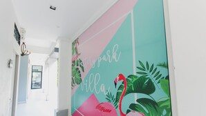 A hallway with a vibrant mural featuring flamingos and tropical leaves, and the words "Battery Park Villa". - The Battery Park Midtown Boutique (Chiang Mai)