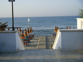 Playa privada, arena blanca, sillas reclinables de playa, sombrillas