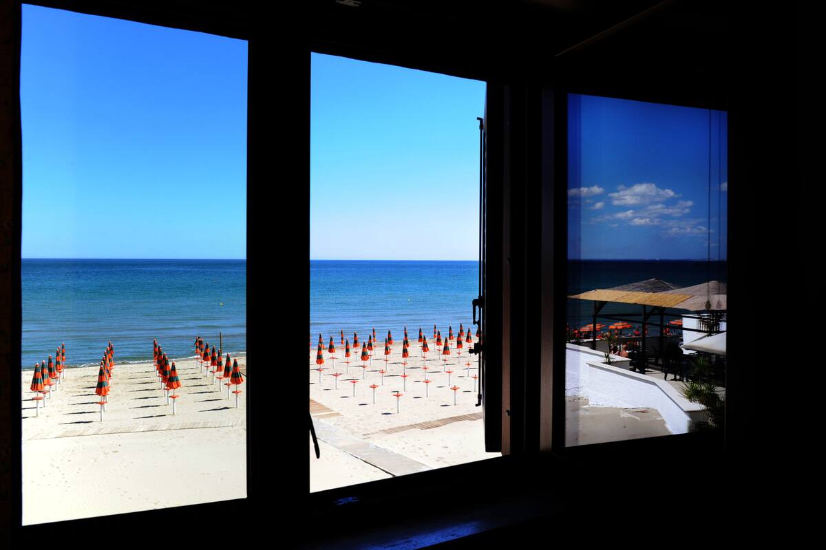 A beach view with umbrellas and a clear sky.
