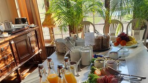 Un buffet de petit-déjeuner proposant une variété d'aliments, de boissons et d'ustensiles.