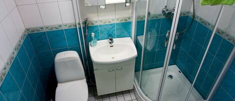 A bathroom with a toilet, sink, and shower.