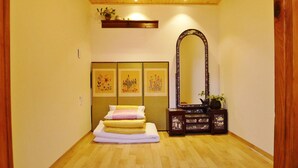 A hallway with a bed, a large mirror, and three framed artworks on the wall. - HanOK Guest House 202 (Seoul)