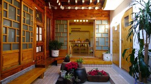 A traditional wooden interior with sliding doors, a tiled floor, and various potted plants. - HanOK Guest House 202 (Seoul)